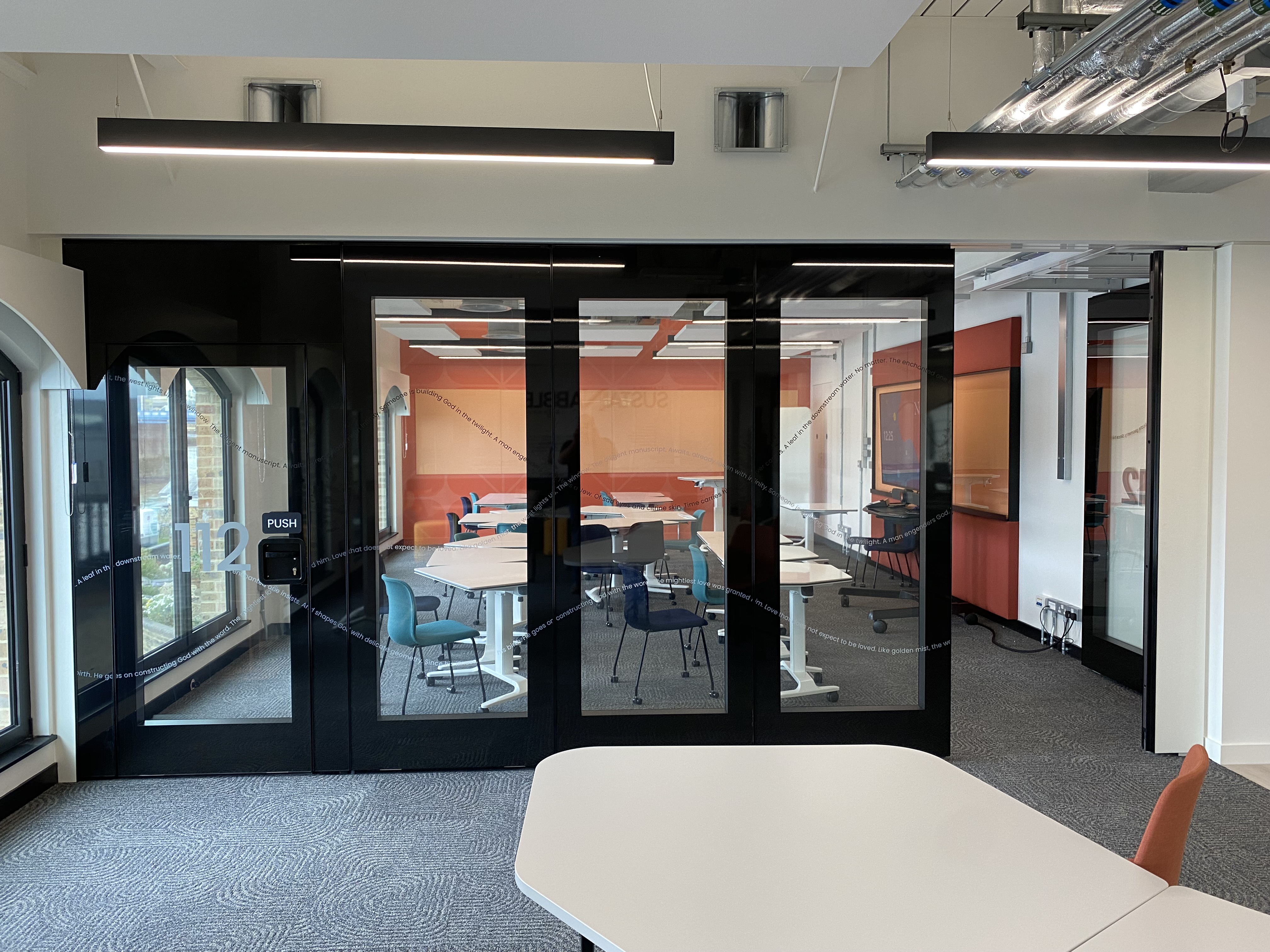 Close-up detail of MG600 flush glazed movable wall top track mechanism and frameless glass panel edge