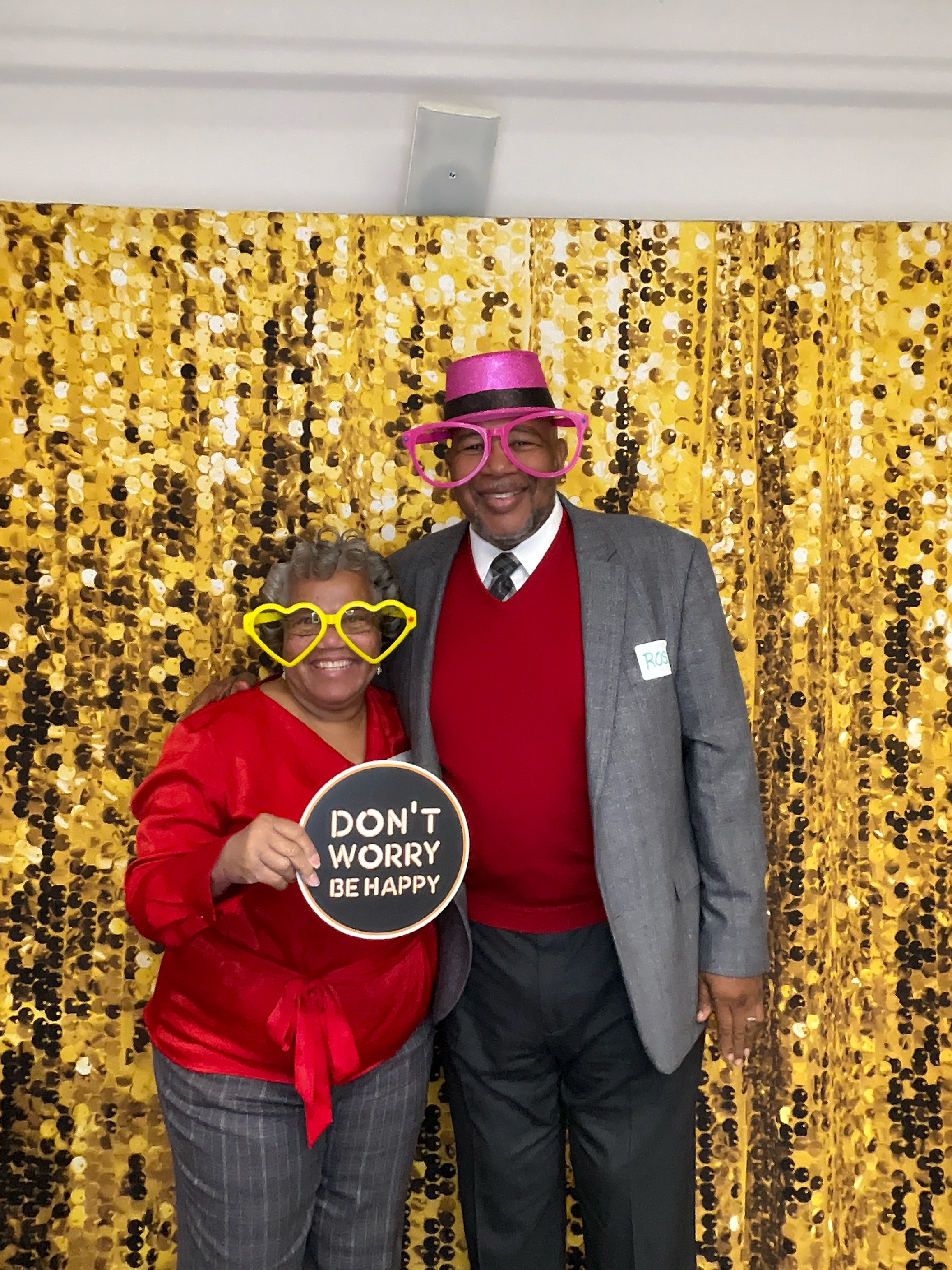 Guests having fun at a photo booth with props and colorful backdrop