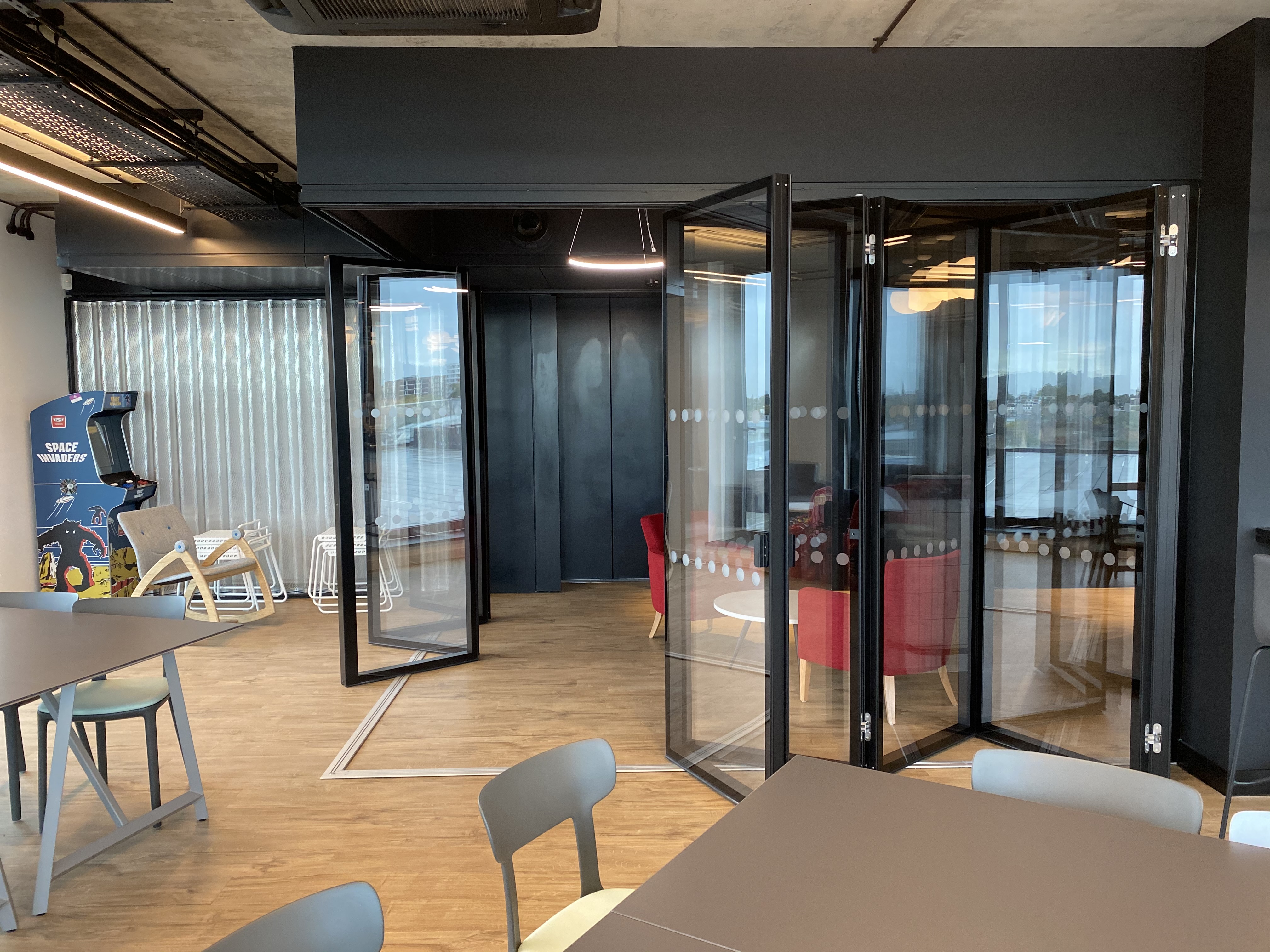 MG500 flush glazed folding partition system — close-up of frameless glass panels and track