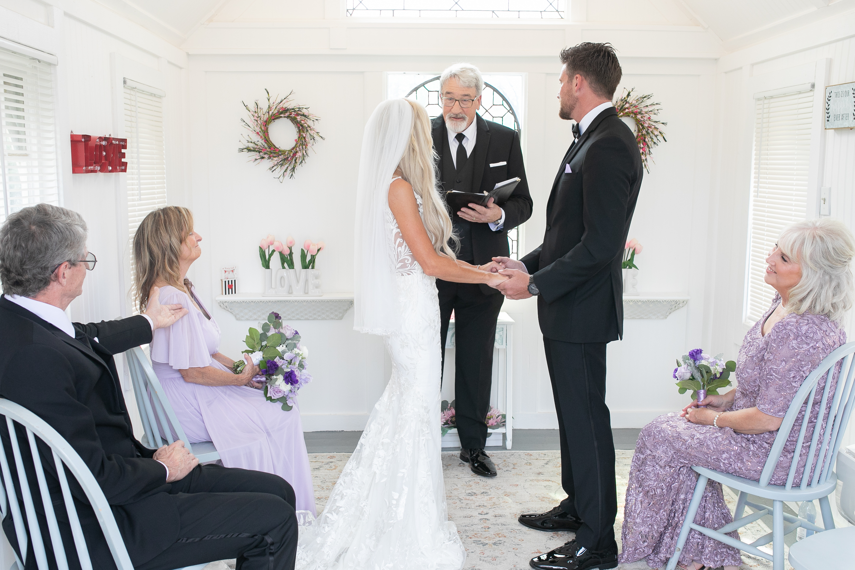 Happy couple sharing their first kiss at the altar of a beautifully decorated intimate chapel during their Maxi Plus Elopement ceremony