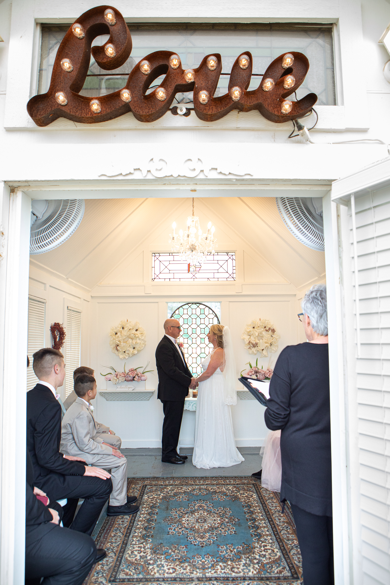 Chapel of Love ATX interior with wooden pews, floral arrangements, and candlelit altar