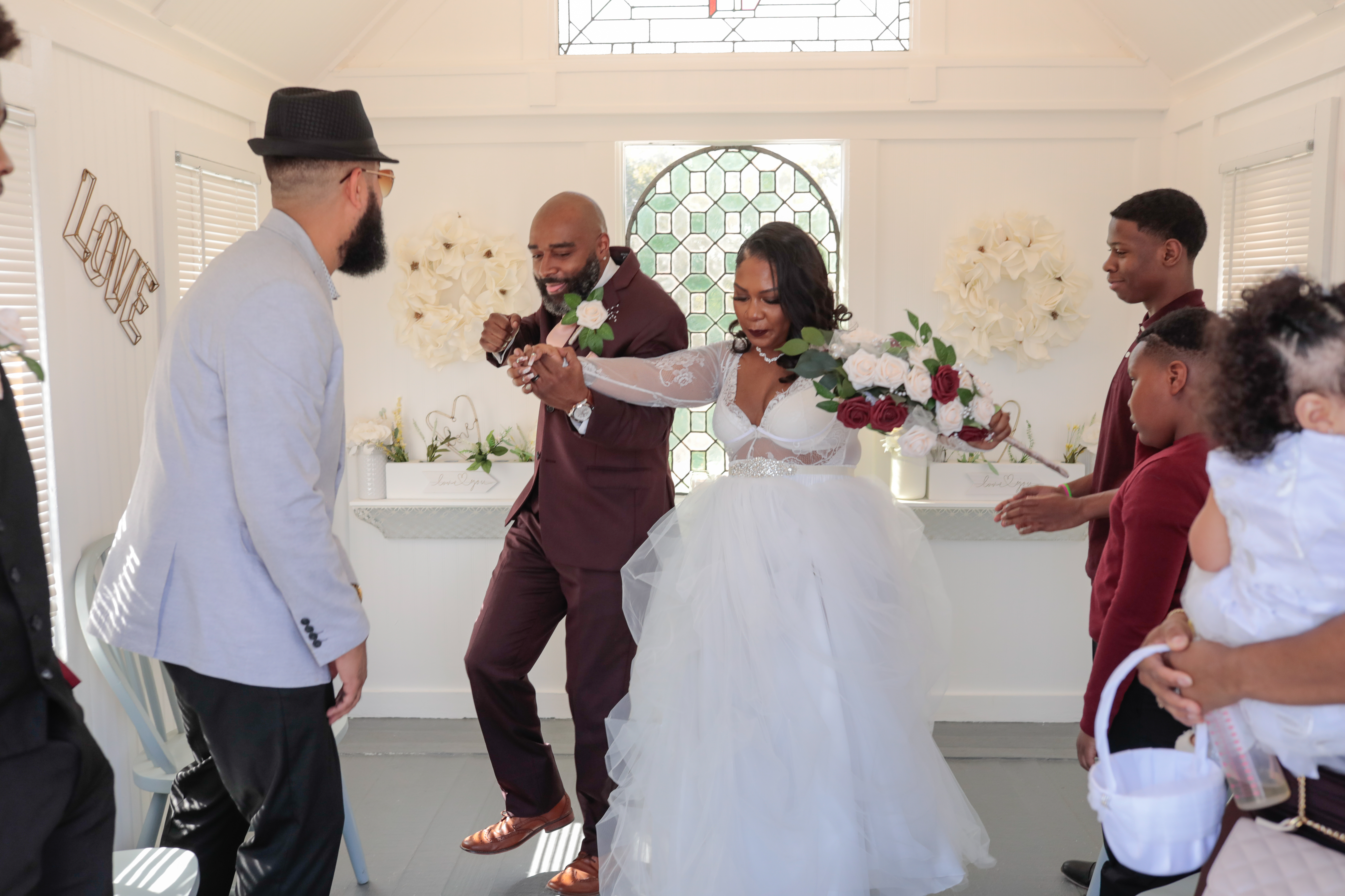 Happy couple sharing their first kiss at the altar of a cozy intimate chapel during their Maxi Elopement ceremony