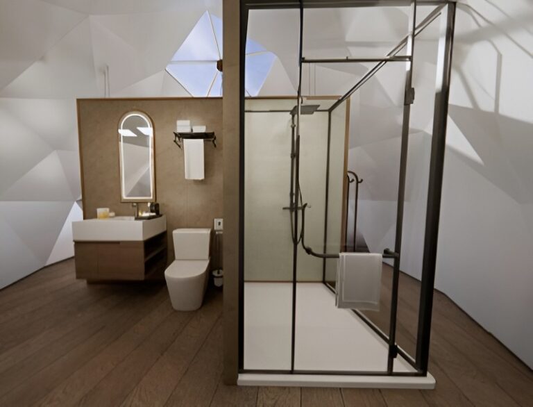 Interior of a modern bathroom in a geodesic dome structure with geometric skylights and glass-enclosed shower.